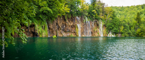 Cascades of pure fresh water rushing down brown, mossy rocks into an azure colored lake at the Plitvice Lakes National Park, Plitvička Jezera, Croatia