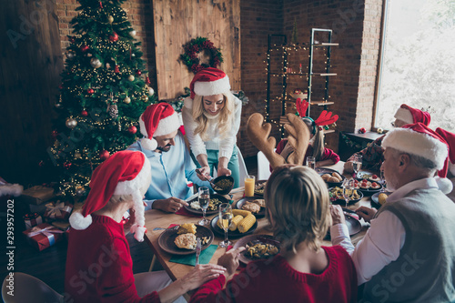 Portrait of nice lovely sweet cheerful cheery big full family brother sister wearing cap hat headwear enjoying season winter tradition feast eating lunch in loft industrial style interior house indoor