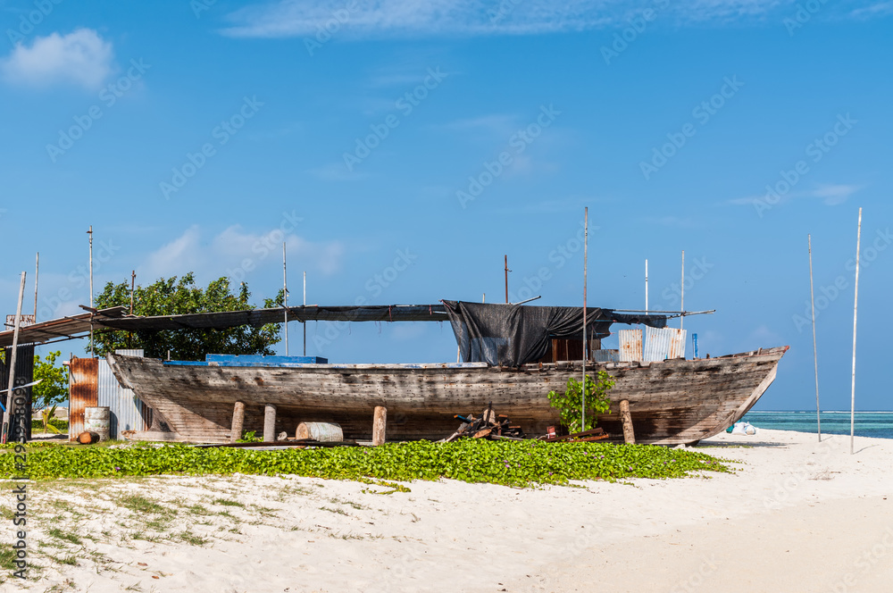 An old wooden fishing boat on the coast of the Maafushi Island, Maldives. Paradise tropical island. Travel and tourism concept.