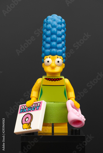 Fotografija Tambov, Russian Federation - Fedruary 07, 2015: Lego Marge Simpson mini figure with pink purse and magazine Donut Fancy on black background