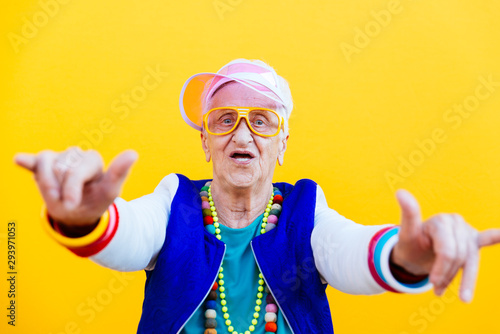 Funny grandmother portraits. 80s style outfit. trapstar dance on colored backgrounds. Concept about seniority and old people photo