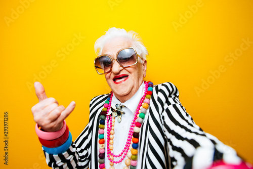 Śmieszne portrety babci. Starsza starsza kobieta ubiera się elegancko na specjalne wydarzenie. modelka babci na kolorowym tle