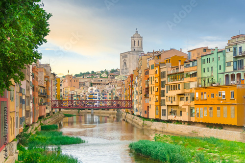 Girona colorful houses district, bridge, and Saint Mary Cathedral, buildings reflected in water in river Onyar. Catalonia Spain.