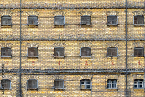 Abandoned jail brick wall and cell windows with bars