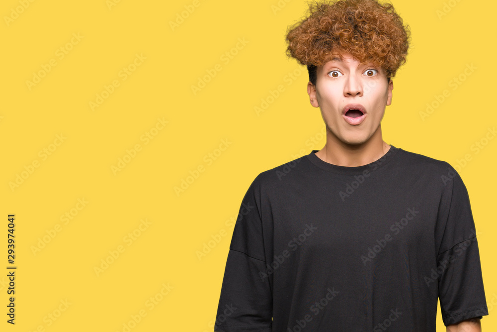 Young handsome man with afro hair wearing black t-shirt afraid and shocked with surprise expression, fear and excited face. Young handsome man with afro hair wearing black t-shirt afraid and shocked with surprise expression, fear and excited face.