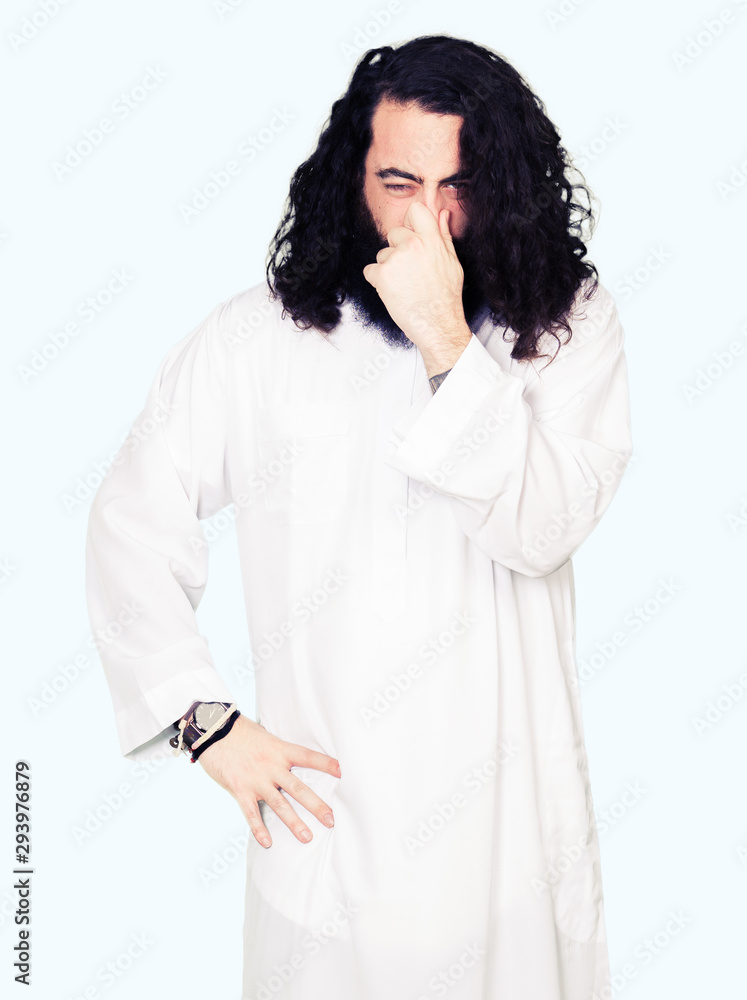 Man wearing Jesus Christ costume smelling something stinky and disgusting, intolerable smell, holding breath with fingers on nose. Bad smells concept. Man wearing Jesus Christ costume smelling something stinky and disgusting, intolerable smell, holding breath with fingers on nose. Bad smells concept.