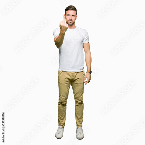 Handsome man wearing casual white t-shirt Showing middle finger, impolite and rude fuck off expression