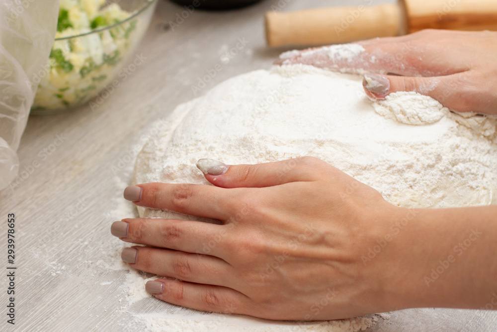 female hands knead flour dough on the table female hands knead flour dough on the table
