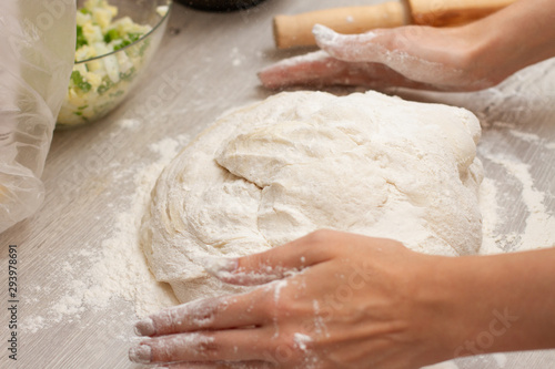 women hands making dough on a table with flour for pies