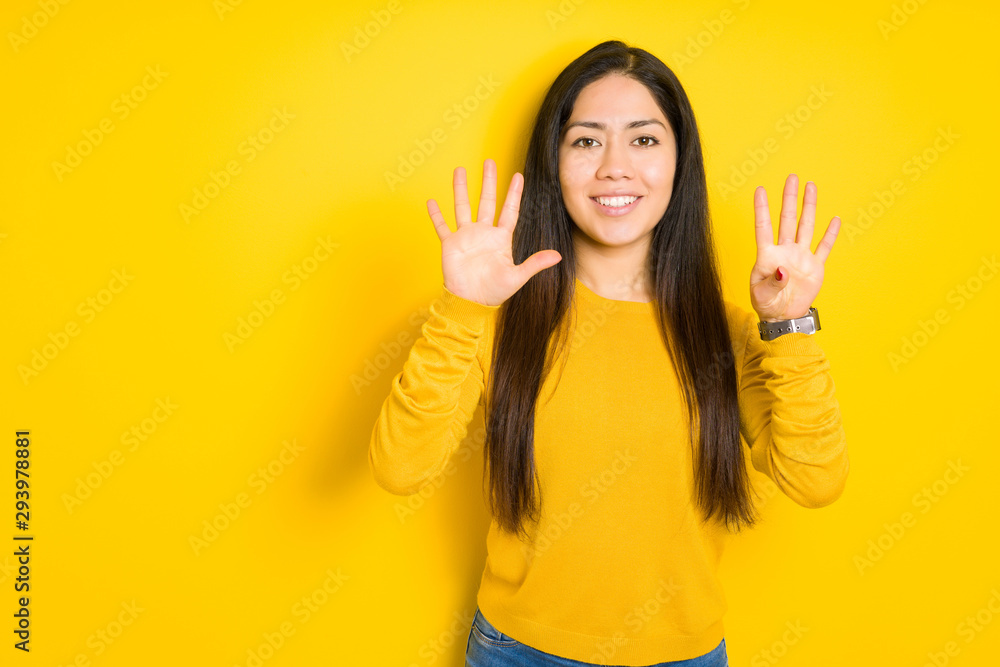 Beautiful brunette woman over yellow isolated background showing and pointing up with fingers number nine while smiling confident and happy. Beautiful brunette woman over yellow isolated background showing and pointing up with fingers number nine while smiling confident and happy.