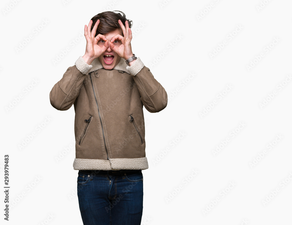 Young handsome man wearing winter coat over isolated background doing ok gesture like binoculars sticking tongue out, eyes looking through fingers. Crazy expression. Young handsome man wearing winter coat over isolated background doing ok gesture like binoculars sticking tongue out, eyes looking through fingers. Crazy expression.