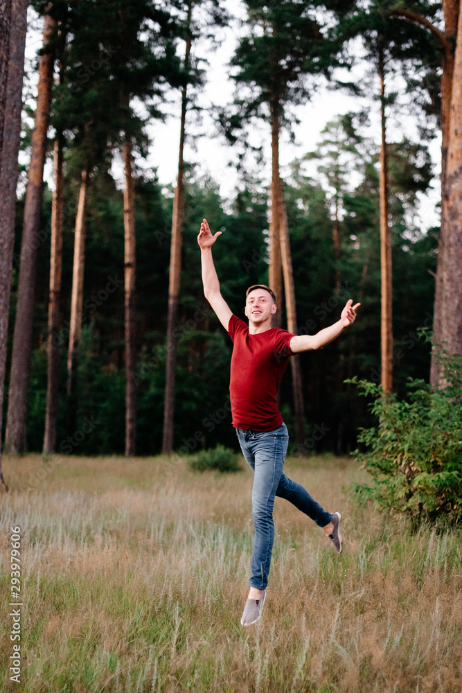 young man dancing in a pine forest