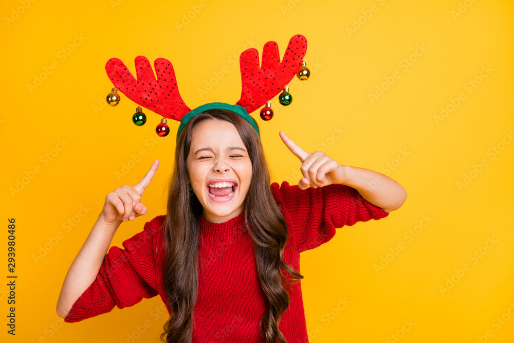Portrait of funny funky crazy brunette hair kid point index finger her reindeer horns headband laughing have fun christmas theme costume party wear stylish sweater isolated bright color background Portrait of funny funky crazy brunette hair kid point index finger her reindeer horns headband laughing have fun christmas theme costume party wear stylish sweater isolated bright color background