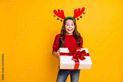 Its for me. Portrait of shocked brunette hair kid receive package big gift on christmas night party scream omg wear fashion pullover denim jeans deer horns headband isolated yellow color background