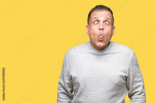 Middle age arab man wearing sport sweatshirt over isolated background making fish face with lips, crazy and comical gesture. Funny expression. © Krakenimages.com