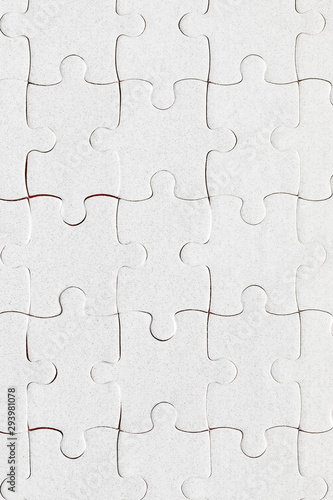 Unfinished white jigsaw puzzle pieces. Fill in pieces of the jigsaw puzzle. Complete the jigsaw puzzle with the missing pieces. Fragment of a folded white jigsaw puzzle. © daliu