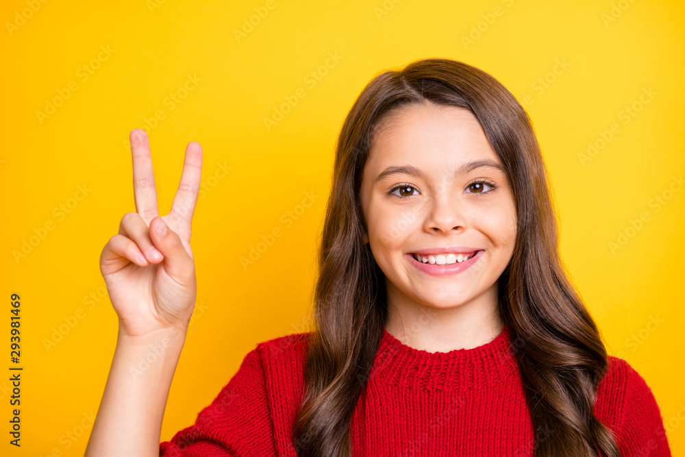 Close up photo of positive cheerful content kid have fun on autumn vacations make v-signs wear good look clothes isolated over yellow color background Close up photo of positive cheerful content kid have fun on autumn vacations make v-signs wear good look clothes isolated over yellow color background