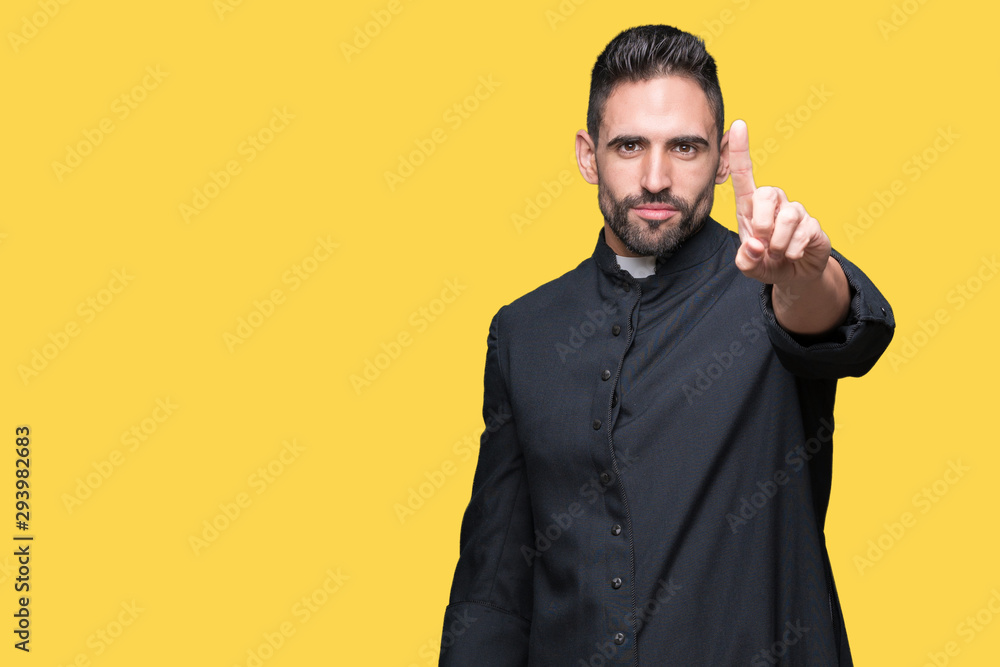 Young Christian priest over isolated background Pointing with finger up and angry expression Young Christian priest over isolated background Pointing with finger up and angry expression