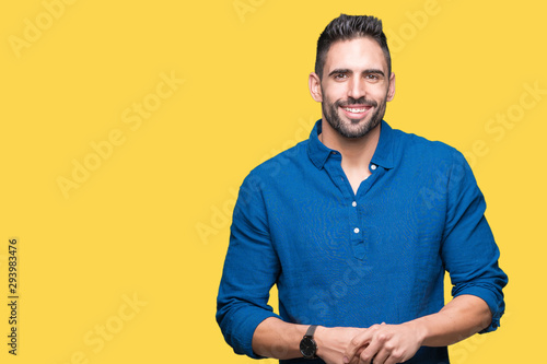 Young handsome man over isolated background Hands together and fingers crossed smiling relaxed and cheerful. Success and optimistic © Krakenimages.com