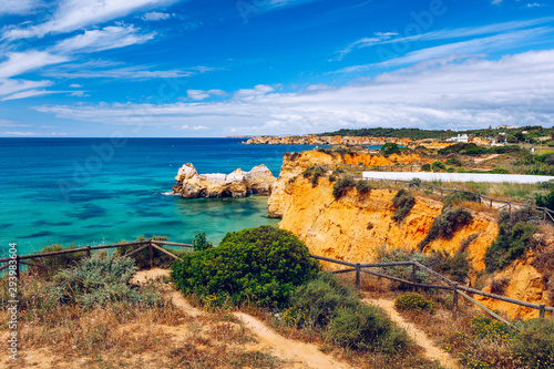 Coastal trail of Portimao on the Algarve coast. Overlooking the cliffs and ocean from the hiking trails in Portimao, Algarve, Portugal. Beautiful coast with wooden path in Portimao, Algarve, Portugal.