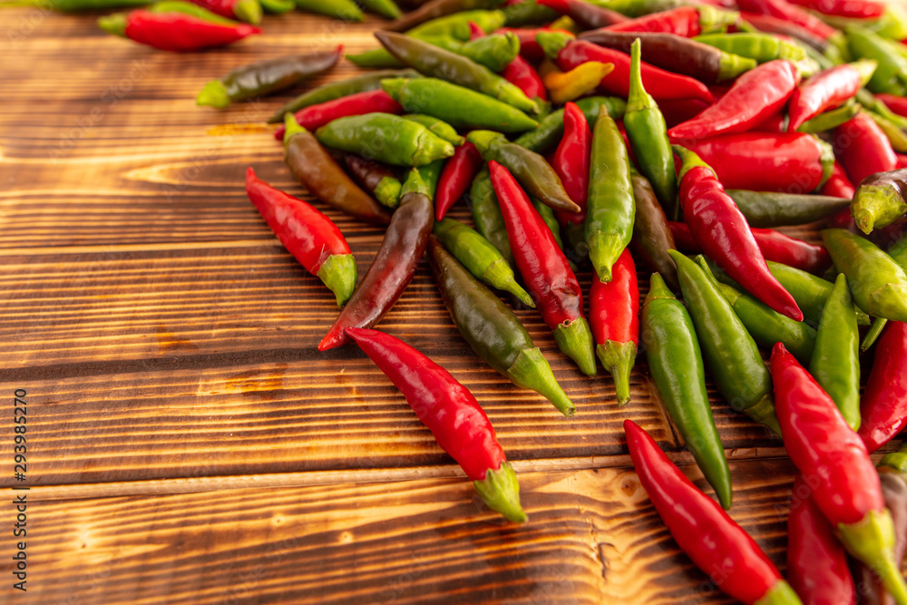 Green and red chili peppers on a wooden board Green and red chili peppers on a wooden board