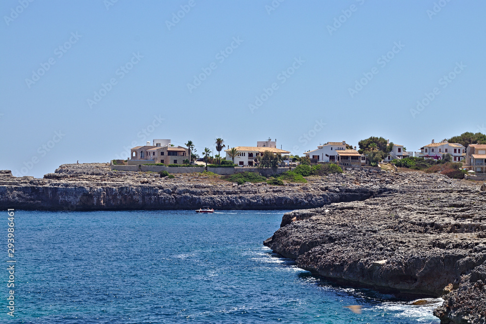 Rocky Coastline with blue sky and houses in the back