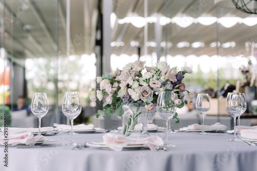 Luxury bouquet of fresh flowers in a glass vase on the holiday round table