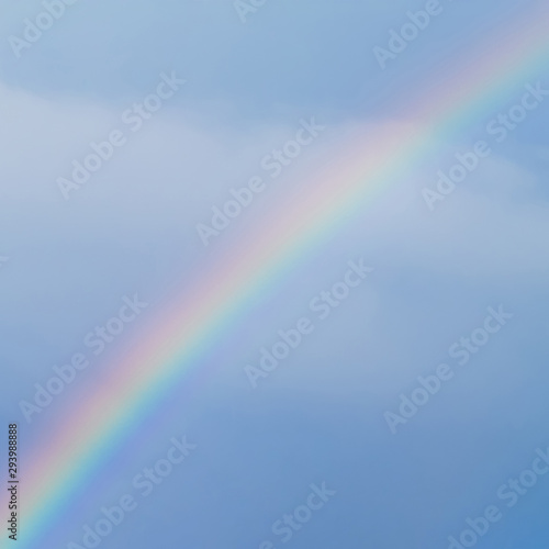 Real rainbow in cloudy blue sky