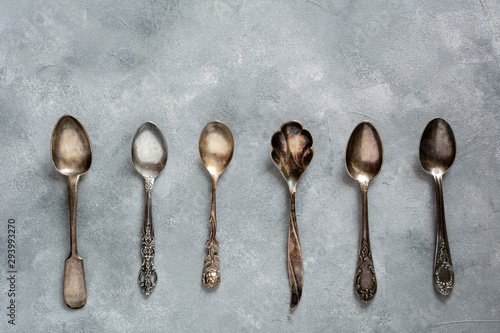 Vintage tea spoons on grey background. Flat lay