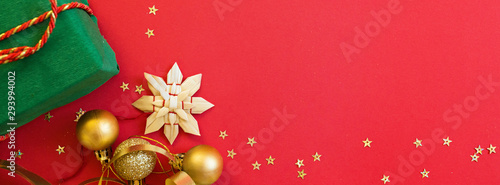 Christmas composition. Gift box  golden toys on red background. new year concept. Greeting card  xmas celebration 2020. Flat lay  top view  copy space  mockup. Banner for web