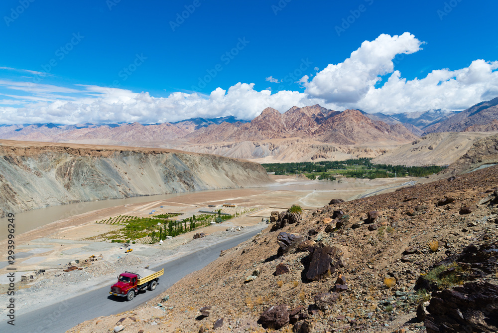 Red truck driving on the highway through mountain landscape. Red truck driving on the highway through mountain landscape.