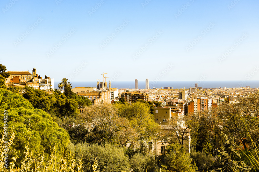 Spring Barcelona general view from mountain Montjuic. Beautiful urban landscape with green hills, gardens, trees, red roofs for architectural print, poster. Bright springtime on Mediterranian sea