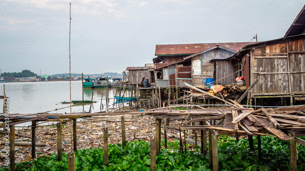 slum wooden houses on the riverbank of Mahakam, Samarinda, Borneo, Indonesia