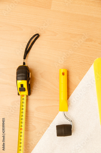 Tools for gluing wallpapers on the laminate floor. A room after renovation. Fresh repair in a room.