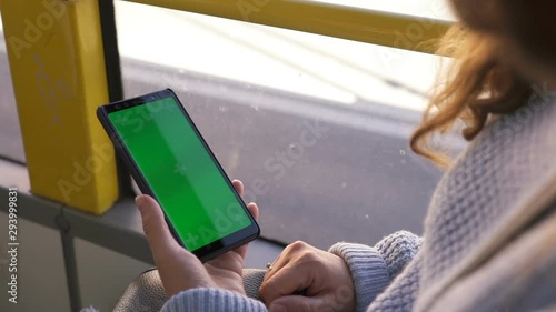 Wallpaper Mural Woman's hand holding a smartphone with a green screen in tram. Chroma key Torontodigital.ca