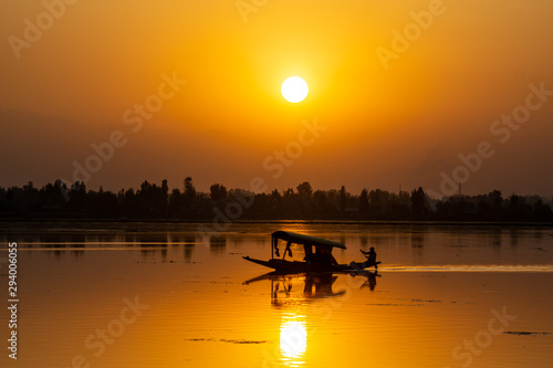 Sunset view over traditional boat or shikara - a type of wooden boat. Shikara are of varied sizes and are used for multiple purposes, including transportation of people.
