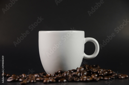 white coffee cup with coffee beans on black background
