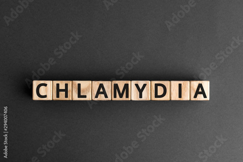 Chlamydia - word from wooden blocks with letters, parasitic bacterium chlamydia concept, grey background photo