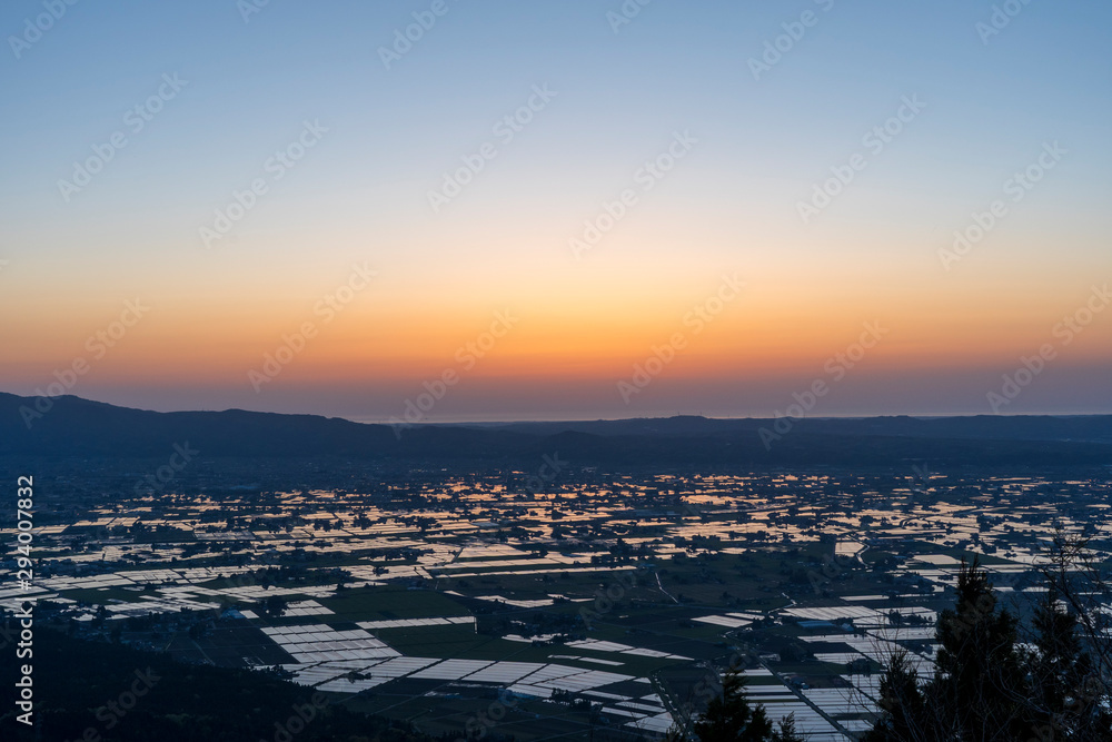 富山県南砺市八乙女山から望む散居村と日本海に沈む夕日