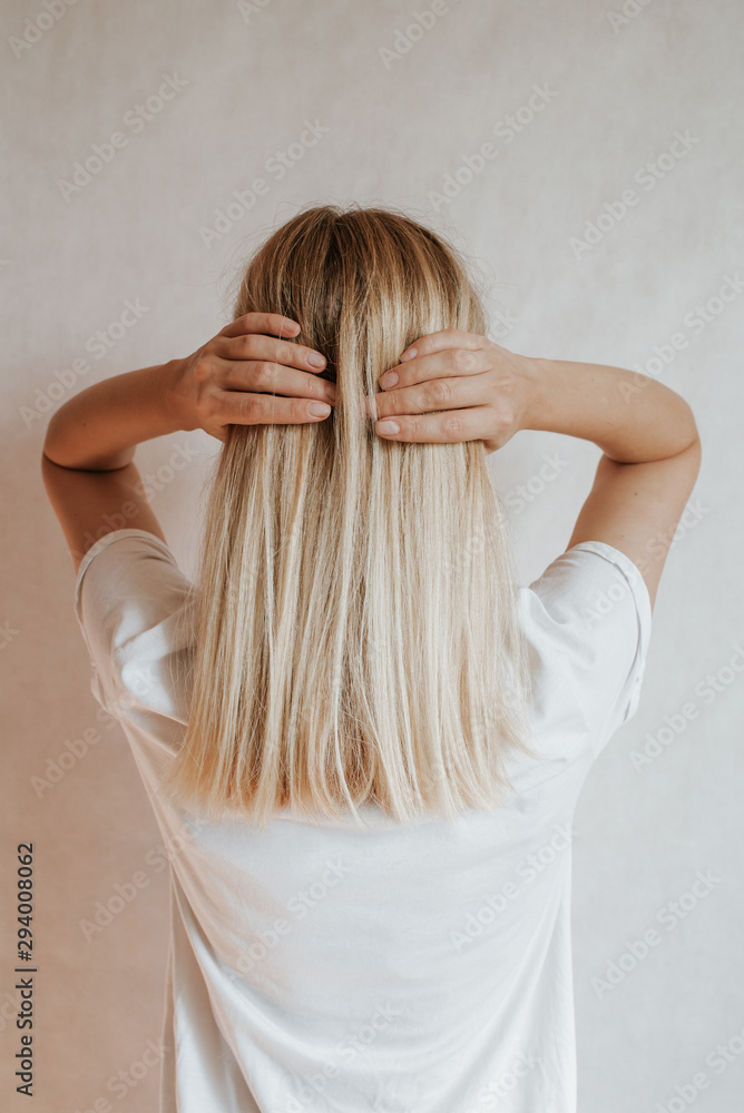 Blond hair woman posing near a light wall. Beautiful young caucasian girl. Hand gestures. Emotion. Casual clothing. Studio model in work. Strong woman, future is female. Jeans and white blank t-shirt Blond hair woman posing near a light wall. Beautiful young caucasian girl. Hand gestures. Emotion. Casual clothing. Studio model in work. Strong woman, future is female. Jeans and white blank t-shirt