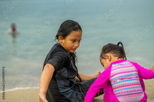 Young asian kids are playing on the beach. Vacation and relax concept. © ellinnur