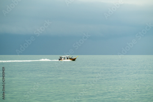 People in fast moving transportation boat crossing the sea. © ellinnur