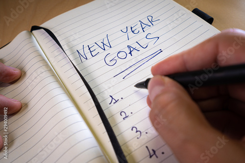hand writing new year's resolutions in a notebook. New year wishes or goals concept photo