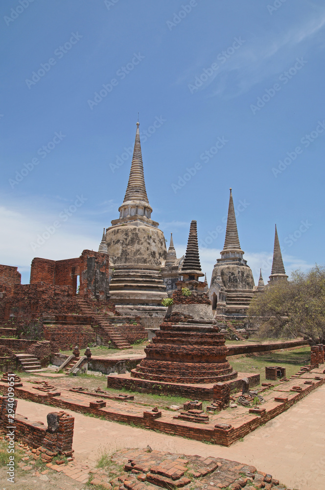 Fototapeta premium Asian religious architecture. Ancient pagoda at Wat Phra Sri Sanphet temple under blue sky. Ayutthaya, Thailand