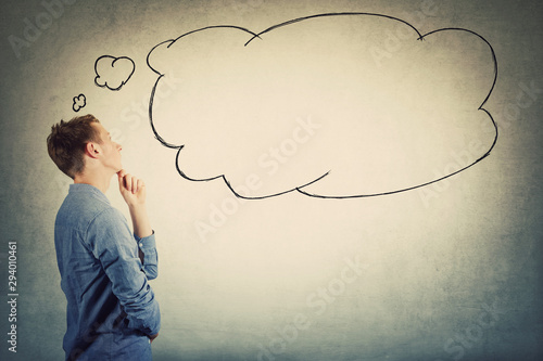 Fotografie Side view of thoughtful student boy teenager keeps hand under chin looking pensive