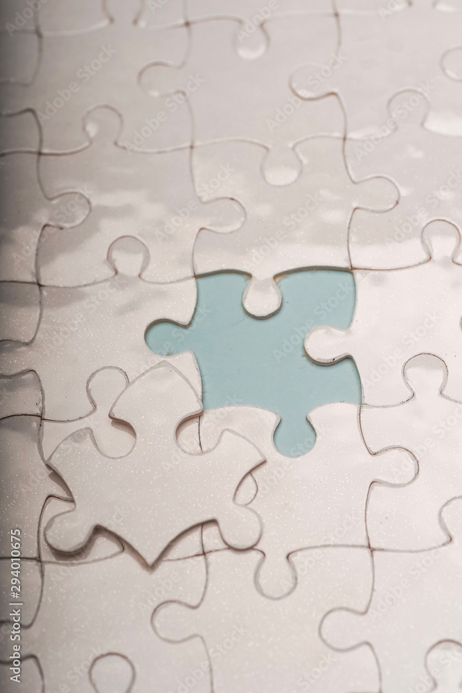 Closed up shot of blank white puzzle pieces, selective focus, copy space for text Closed up shot of blank white puzzle pieces, selective focus, copy space for text