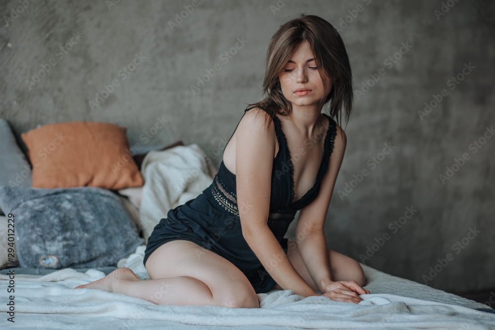 Cute girl sitting on bed in morning in black lingerie Cute girl sitting on bed in morning in black lingerie