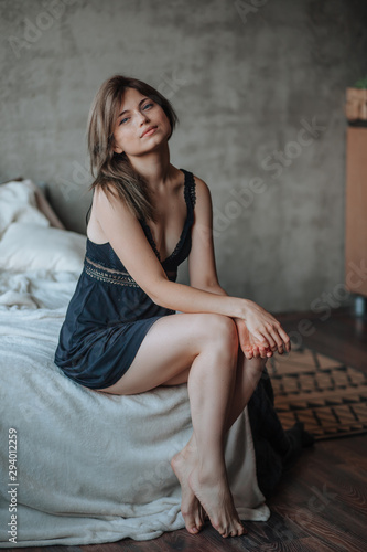 Girl with beautiful legs sitting on the bed