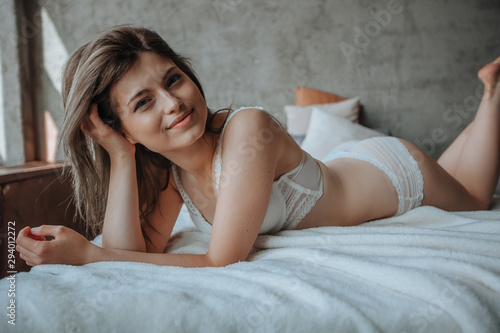 Cute girl lying in the morning on the bed in white linen