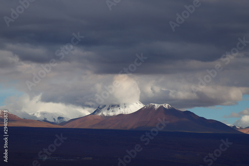 View of the Andean volcanoes covered by clouds and snow, Atacama Desert, Chile